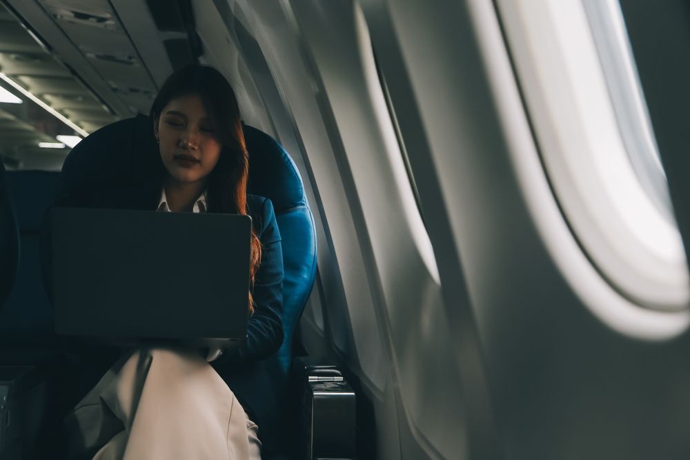 Девушка в самолете с ноутбуком
